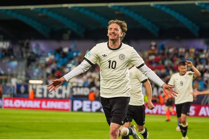 Nick Woltemade im Trikot des VfB Stuttgart vor dunklem Hintergrund, mit Bayer-Leverkusen-Logo rechts oben und dem Text „65 MILLIONEN EURO ANGEBOT – WOLTEMADE“ in kräftiger Schrift darunter.